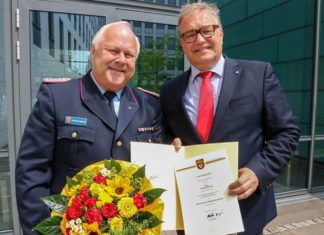 Mit Nadel, Urkunde und Blumen: Regionspräsident Hauke Jagau (r.) gratuliert Eberhard Schmidt zur Ernennung als stellvertretender Regionsbrandmeister. Foto: Region Hannover